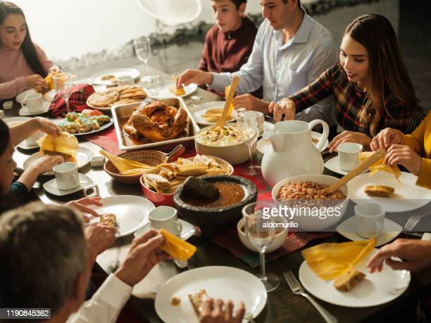 Latin people eating traditional mexican food at the table for christmas.