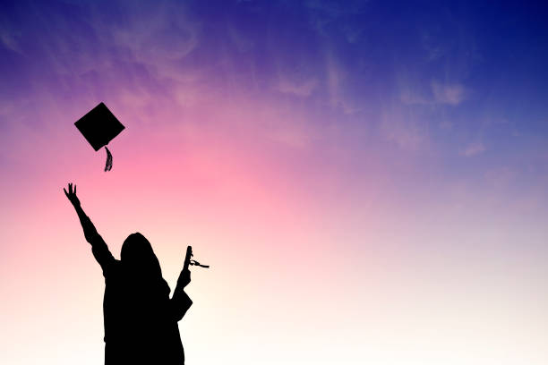 Graduate students tossing up hats over sky