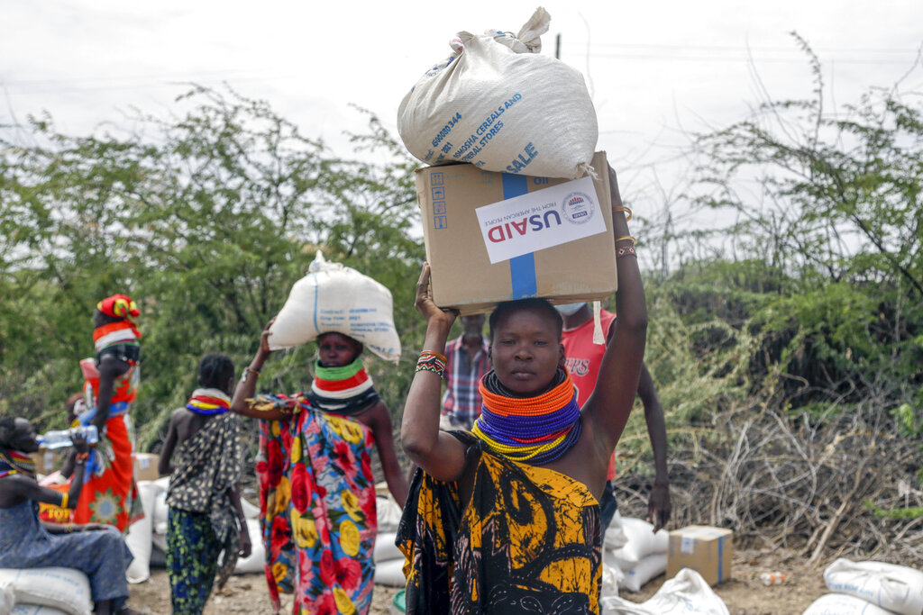 Locals residents carry a boxes and sacks of food distributed by the United States Agency for International Development (USAID), in Kachoda, Turkana area, northern Kenya, Saturday, July 23, 2022. Samantha Power, Administrator of the United States Agency for International Development (USAID) visited Kachoda Saturday with the intention to put measures in place that would help avert a hunger crisis in East Africa. (AP Photo/Desmond Tiro). 
Photo courtesy of https://ru.usembassy.gov/the-united-states-announces-more-than-380-million-in-additional-humanitarian-assistance-for-africa/